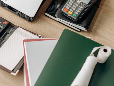 Stack of documents and a laptop on desk